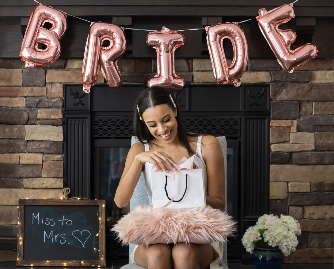 Young beautiful woman opening gift bag at her bridal shower